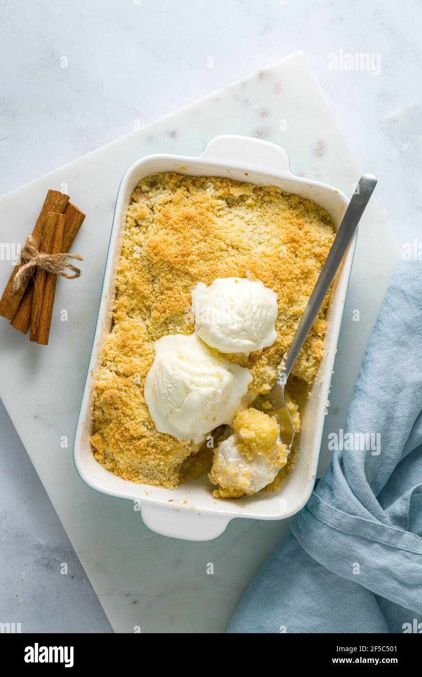 Mela e pera crumble con gelato, streusel. Dolce dessert con frutta in umido. Vista dall'alto, verticale Foto Stock