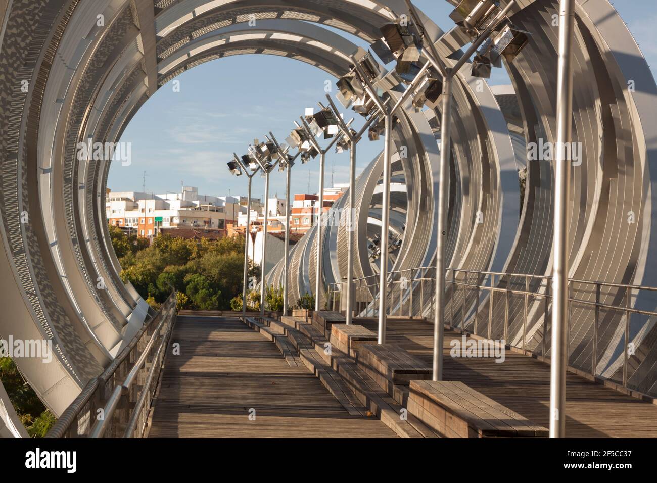 Ponte a spirale in metallo sul fiume Madrid, ingegneria moderna. Parco sul fiume Manzanares. A Madrid Spagna Foto Stock