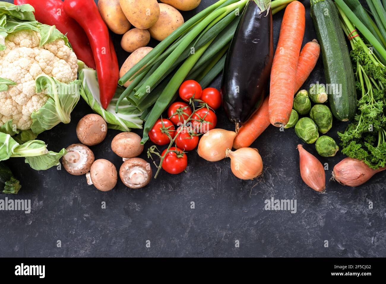 Varie verdure sane su uno sfondo di ardesia grigio scuro, concetto di cibo per dieta di idoneità e perdere peso, spazio di copia, vista ad angolo alto dall'alto, sel Foto Stock