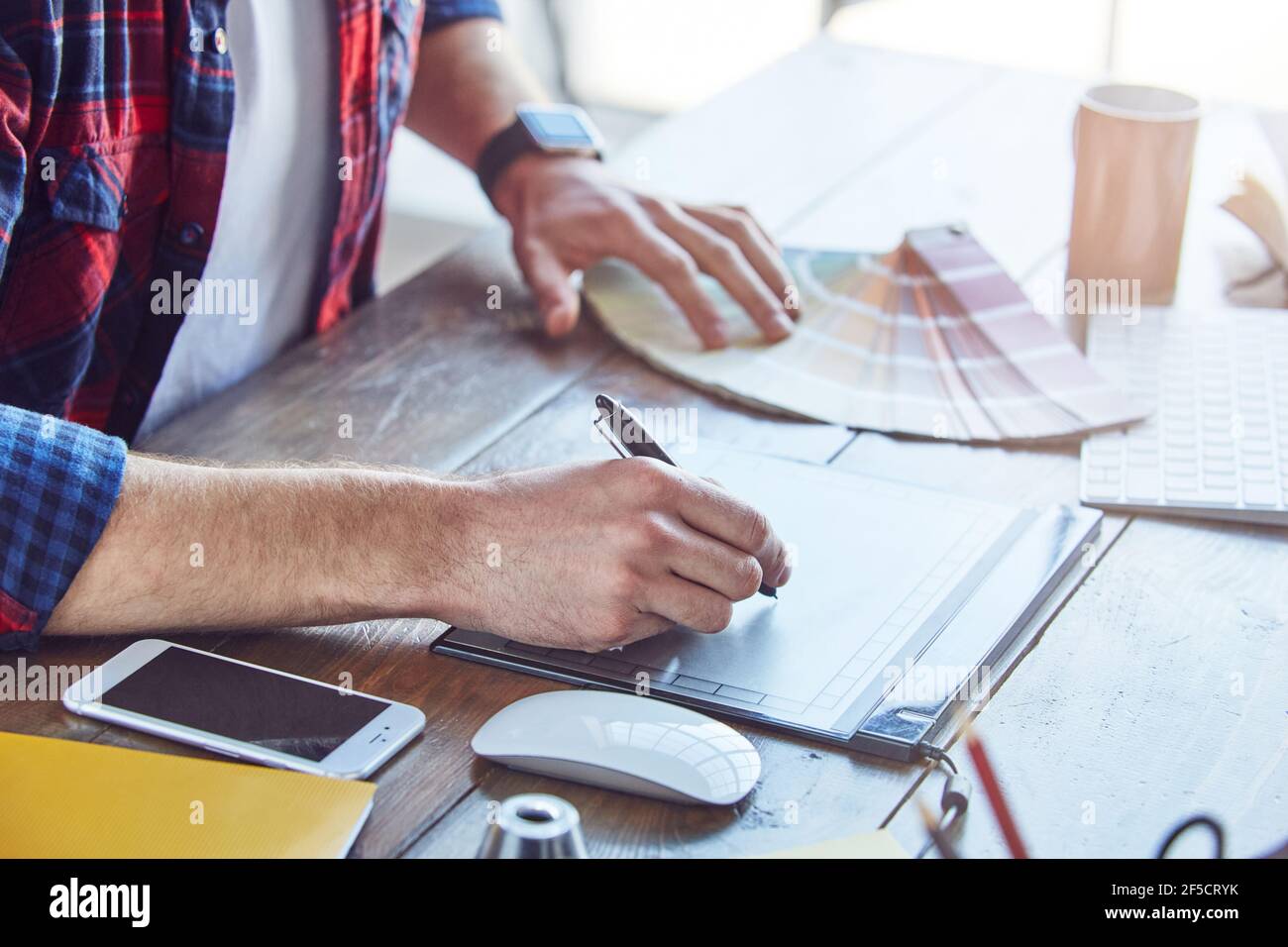 Uomo che disegna un nuovo progetto scegliendo i campioni di colore nella creatività moderna studio Foto Stock