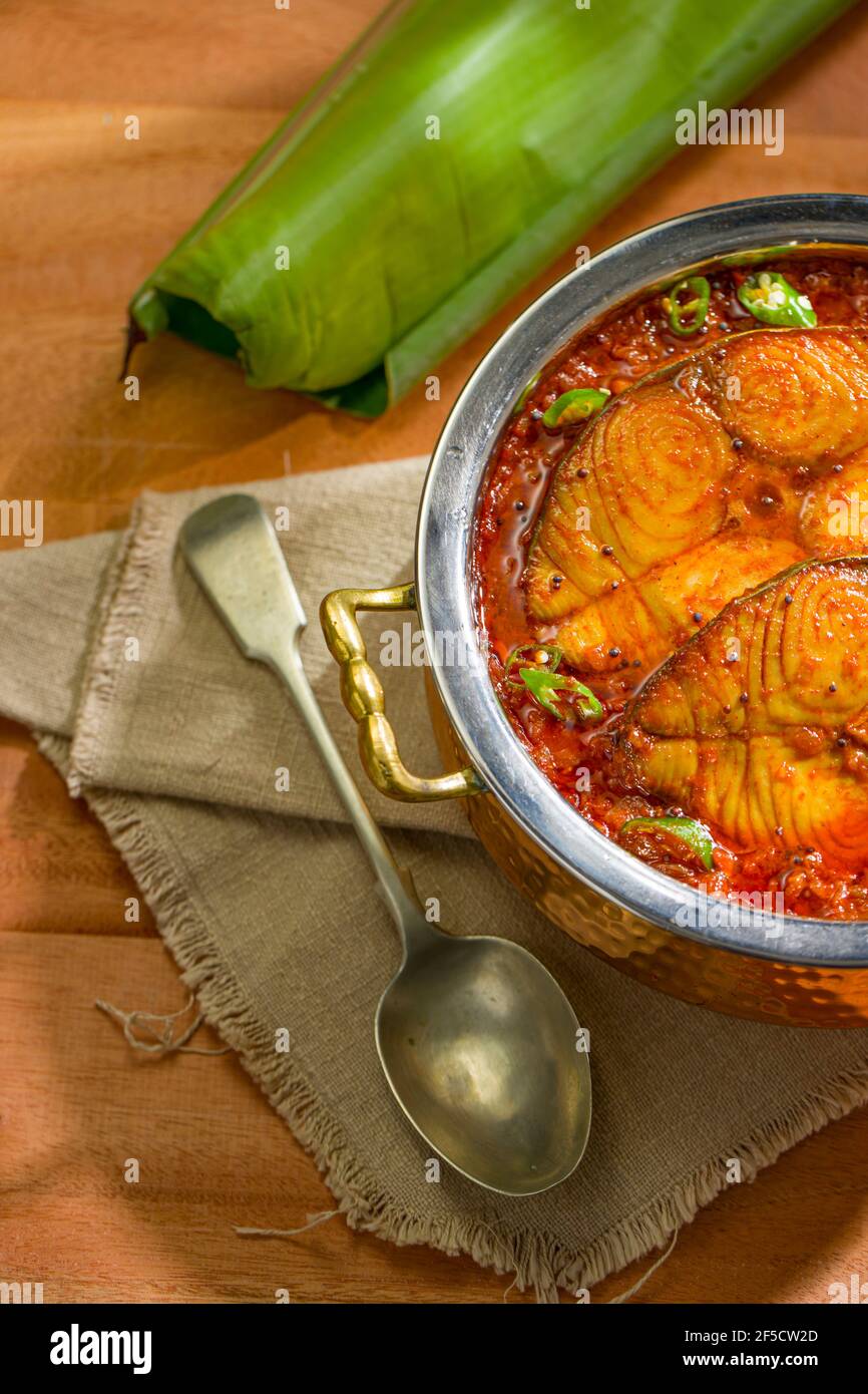 Pesce di cervo curry, curry tradizionale indiano di pesce, kerala speciale, disposto in una ciotola di servizio di rame guarnito con tamarindo malabarese e chil fresco verde Foto Stock