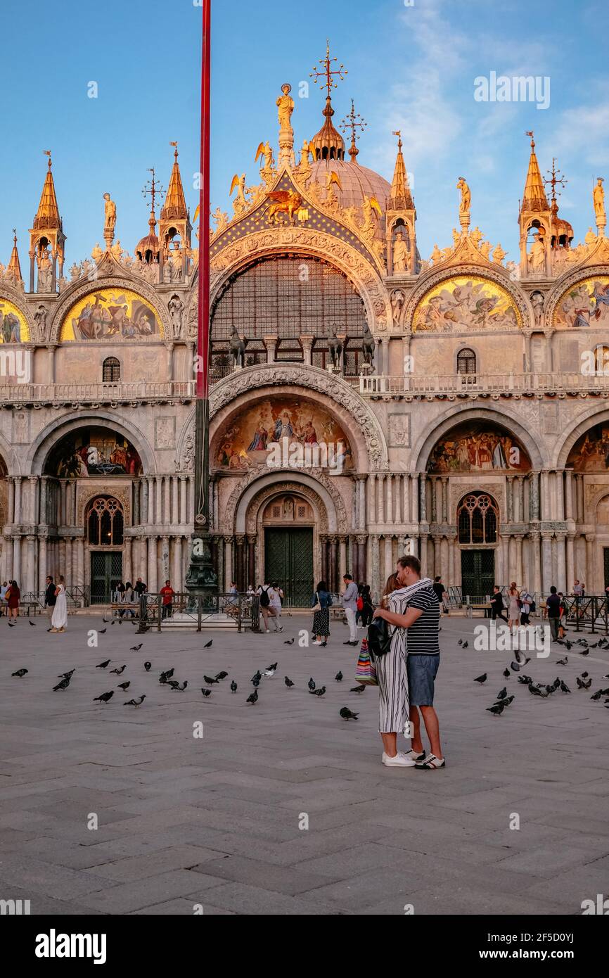 Una coppia si abbraccia di fronte alla Basilica di San Marco a Venezia al Tramonto - la Città più romantica del mondo, Italia Foto Stock