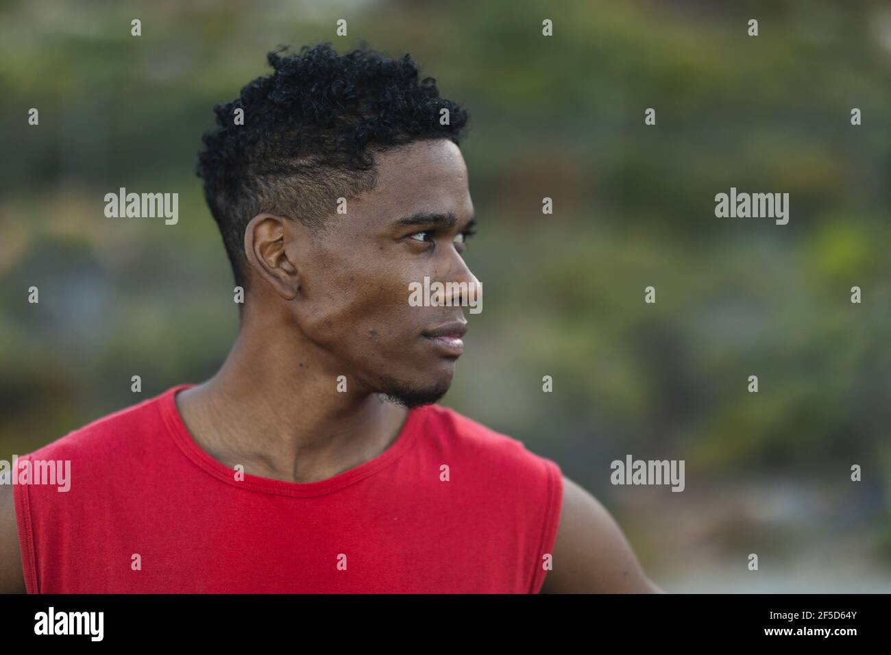 Ritratto di uomo afroamericano che si esercita all'aperto guardando a. un lato su una strada costiera Foto Stock