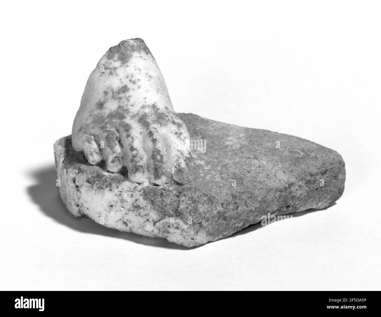 Frammento di un piede da una statua. Un piede destro frammentario di una statuetta è conservato su una base è approssimativamente romboide nella forma. Parte della punta grande è mancante dal piede che è conservato dalla parte anteriore dell'arco in avanti. Le dita dei piedi sono molto lunghe, la seconda e la terza punta sono lunghe 3.0 cm. Il trapano è stato utilizzato per la spaziatura delle dita dei piedi e il contorno interno del gradino. Le articolazioni e le unghie di tutte le dita dei piedi sono scolpite tranne che per la prima punta che è rotto via. La modellazione è di buona qualità. Non rimane abbastanza del piede per indicare la sua posizione o il tipo di composizione a WI Foto Stock
