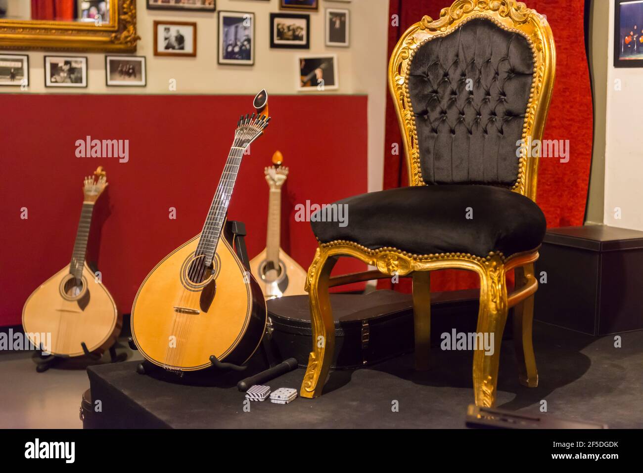 Vita morta di tre chitarre portoghesi Coimbra e di una sedia prima di un concerto di Fado a Coimbra, Portogallo. Foto Stock