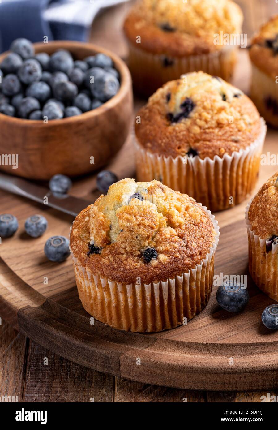 Deliziosi muffin ai mirtilli con frutti di bosco freschi su legno rustico piatto Foto Stock