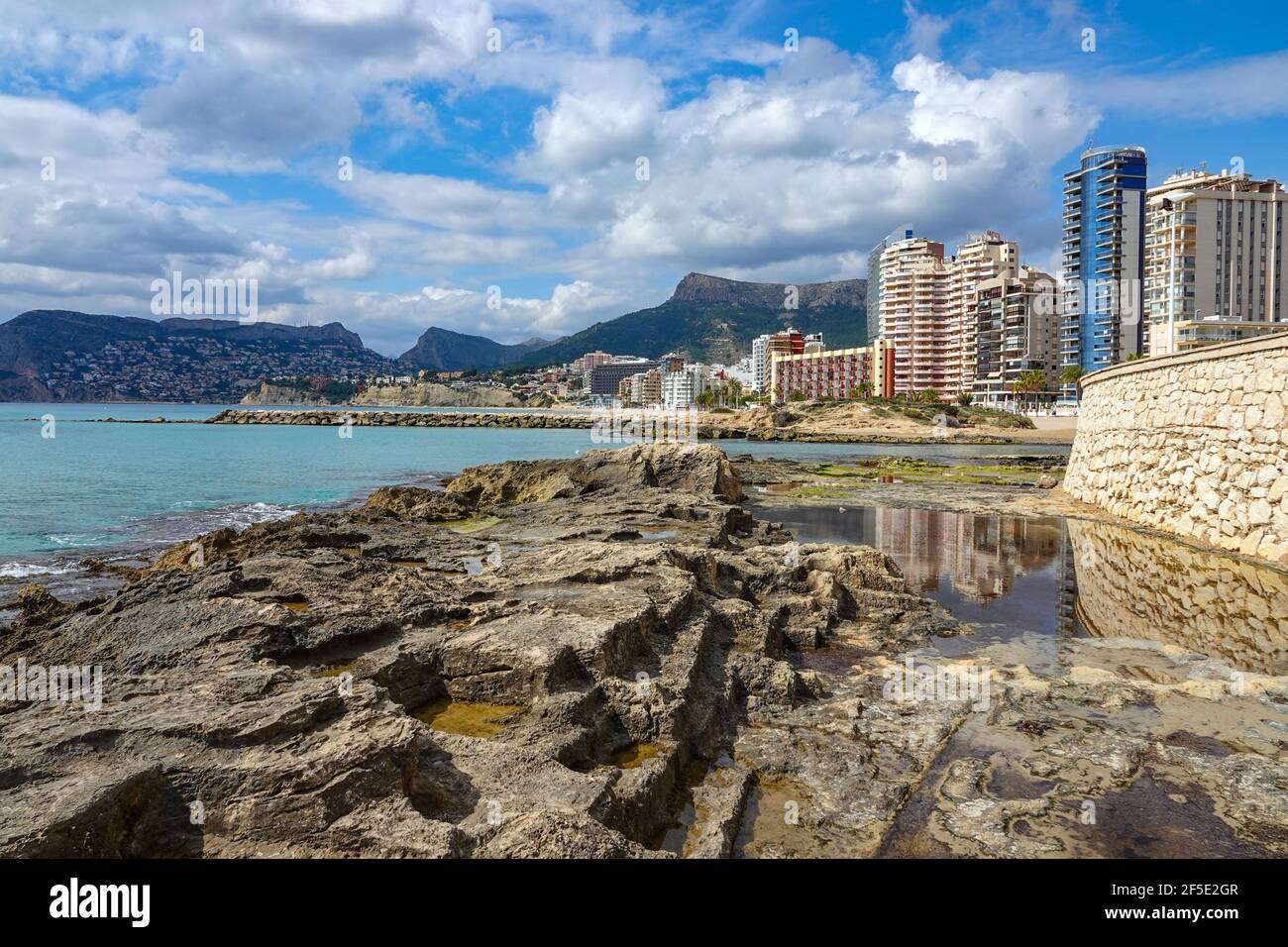 Piscine del Queens Baths e Playa de Calp spiaggia con blocchi di appartamenti e montagne circostanti Calpe, Calp, Costa Blanca, Spagna, in inverno Foto Stock