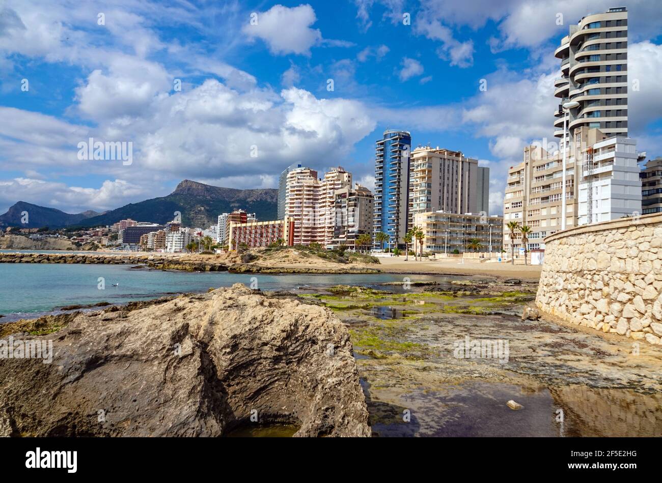 Playa de Calp spiaggia con blocchi di appartamenti e montagne circostanti Calpe, Calp, Costa Blanca, Spagna, in inverno Foto Stock