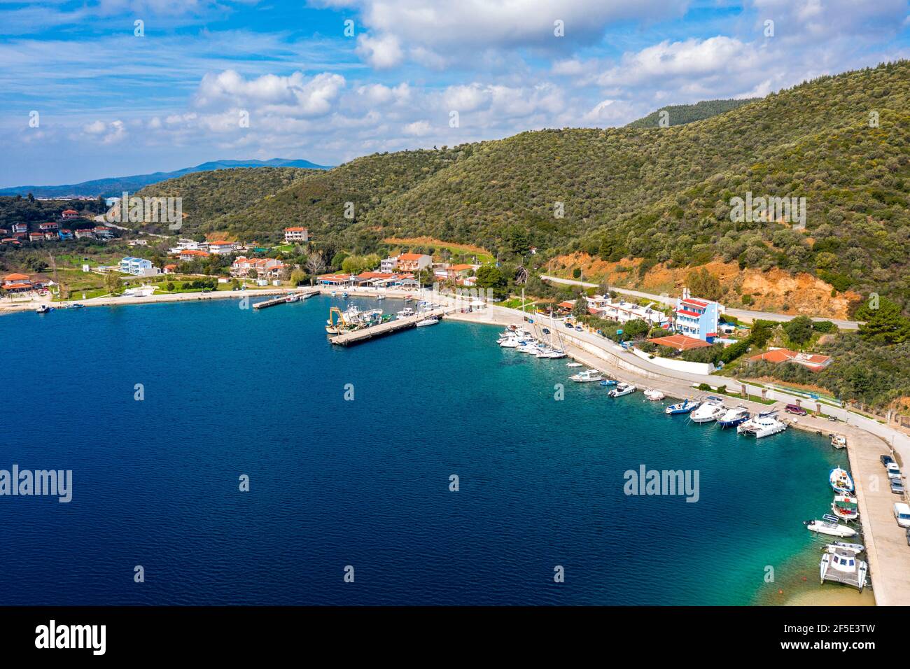 Paese di campagna europeo sulla costa mediterranea con molo costa per barche da pesca. Piccola località turistica con ville vacanze lungo la foresta verde hi Foto Stock