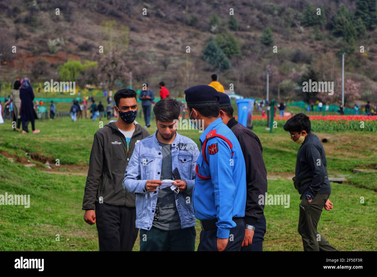 Srinagar, India. 25 Marzo 2021. Un poliziotto che chiede ad un ragazzo la sua maschera facciale in giardino di tulipani Srinagar il 25 marzo 2021.aumento in covid19 casi sono stati visti in valle dalla settimana scorsa pochi morti sono stati riportati anche. (Foto di Muhammad Manan/Pacific Press) Credit: Pacific Press Media Production Corp./Alamy Live News Foto Stock