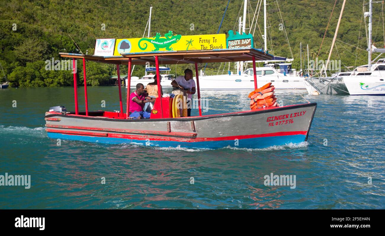 Marigot Bay, Castries, St Lucia. Traghetto colorato da LaBas Beach che si avvicina al molo. Foto Stock
