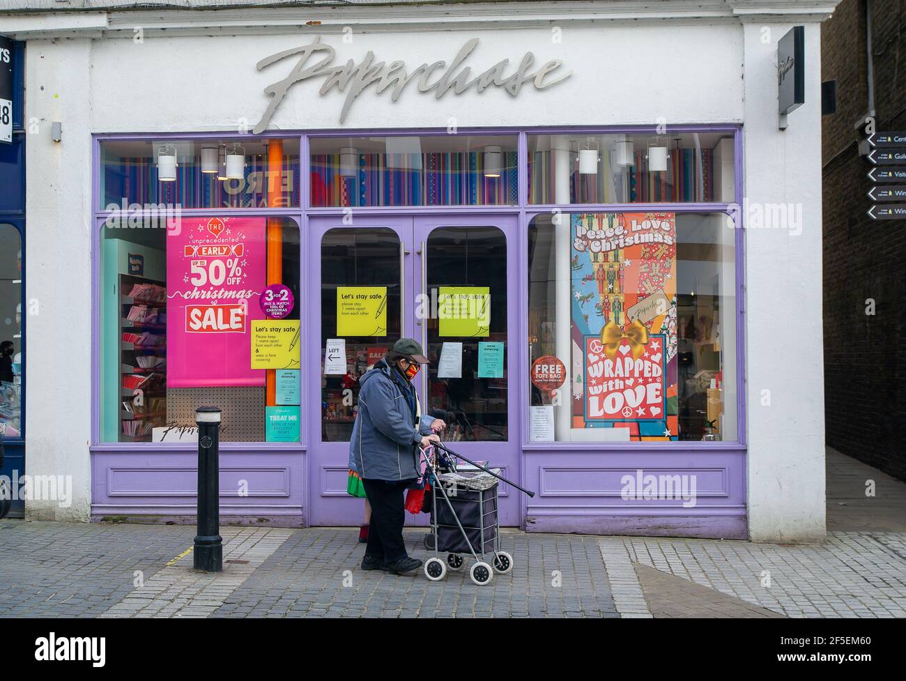 Windsor, Berkshire, Regno Unito. 23 Marzo 2021. Una coppia anziana cammina oltre il negozio Paperchase. Un anno fa oggi l'Inghilterra è entrata nel primo blocco di Covid-19. Windsor è stata molto tranquilla oggi in quanto molte persone continuano a seguire il soggiorno all'interno delle normative governative. Credito: Maureen McLean/Alamy Foto Stock