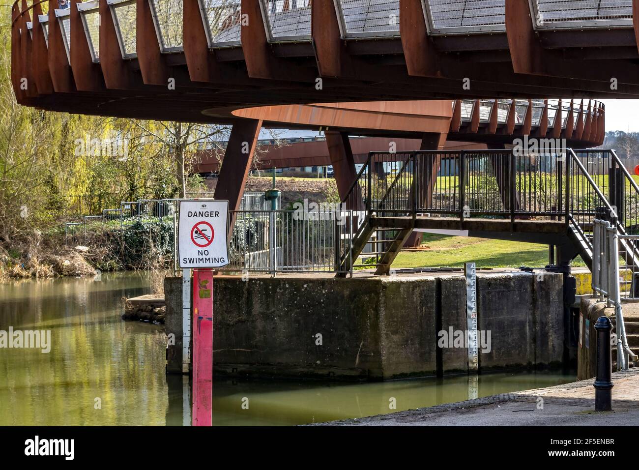 Un ponte di ferro arrugginito che attraversa il fiume Nene e conduce all'Università di Northampton, Inghilterra, Regno Unito. Foto Stock
