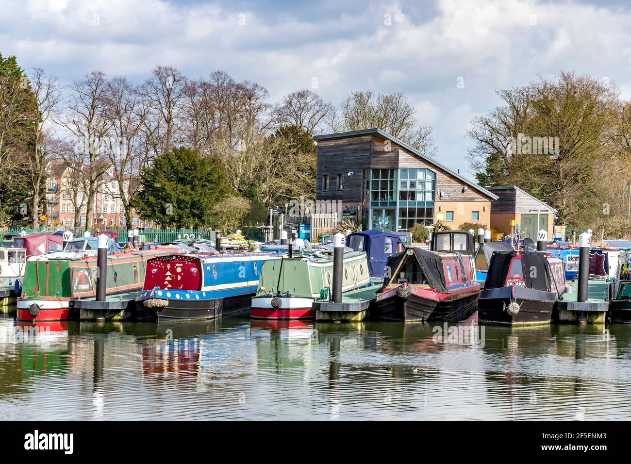 Barche strette ormeggiate presso il porto turistico in un caldo pomeriggio di primavera appena fuori dal fiume Nene, alla periferia di Northampton, Inghilterra, Regno Unito. Foto Stock