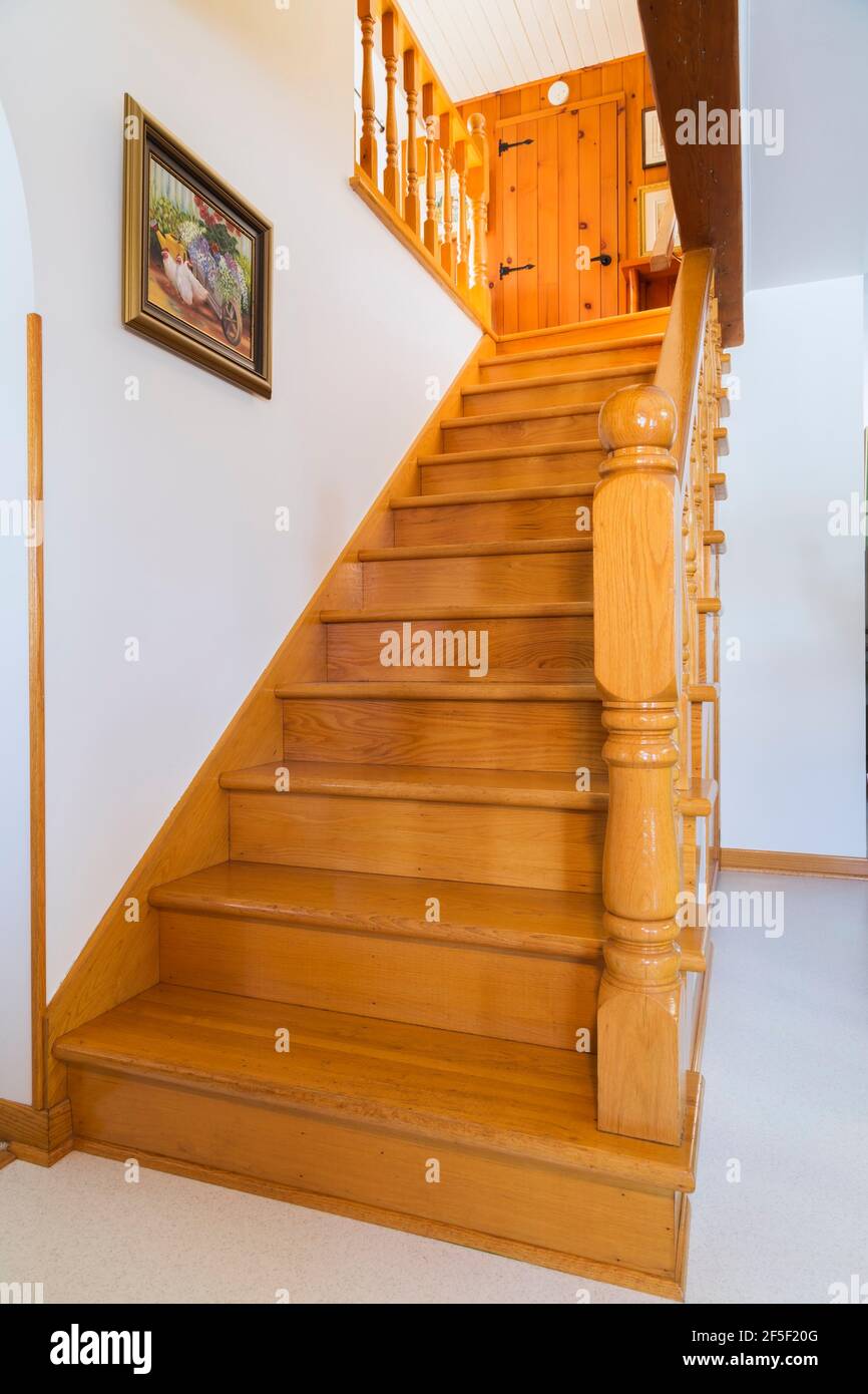Scala in legno di quercia naturale laccato che conduce al piano superiore all'interno di un vecchio fiume 1807 e fieldstone casa stile cottage. Foto Stock