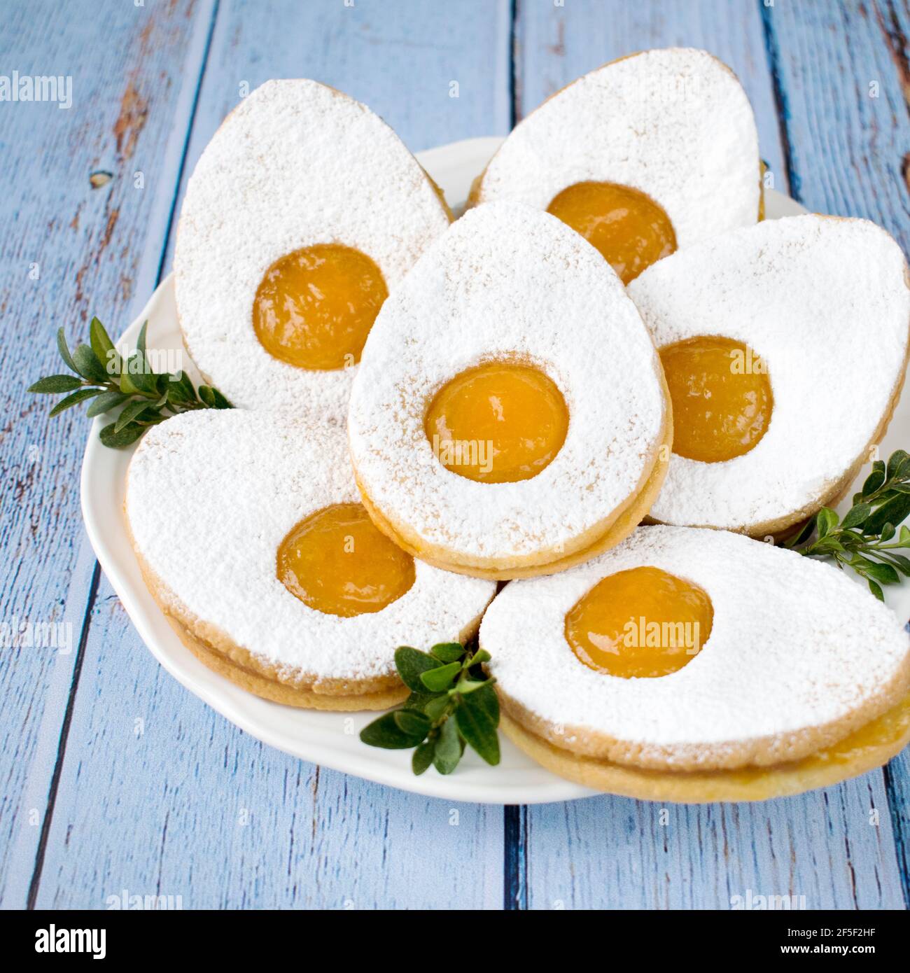 Piccoli muffin di Pasqua, ripieni di crema pasticcera e cosparsi di zucchero in polvere. Foto Stock