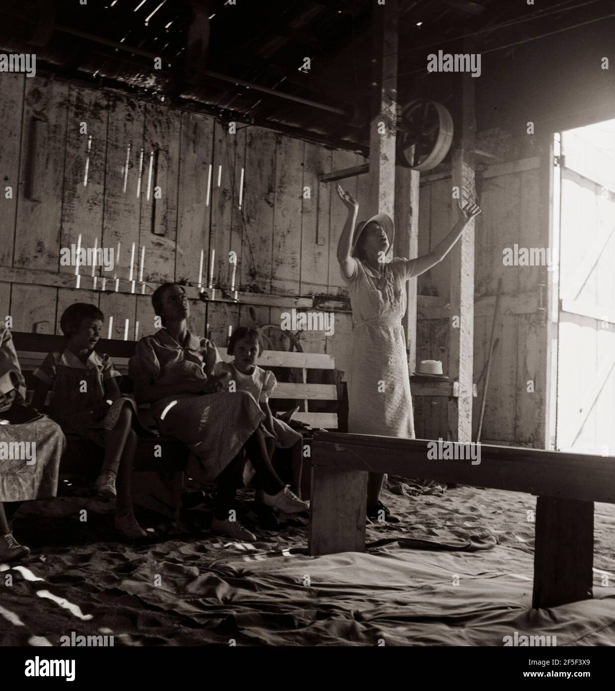 " Vittoria attraverso la Società di Cristo " che tiene la sua Domenica mattina Revival in un garage. DOS Palos, California. Testimonianza: 'E' un meraviglioso salvatore, Gloria a Dio. Sono così felice che sono venuto a casa. Lodate Dio. Il suo amore è così meraviglioso. Sta arrivando presto. Voglio lodare il Signore per ciò che è per me. Mi salvò una volta e mi riempì dello Spirito Santo. Hallalulah! Egli riempirà oggi il vostro cuore di traboccante. Benedite il suo Santo nome . Giugno 1938. Fotografia di Dorothea Lange. Foto Stock