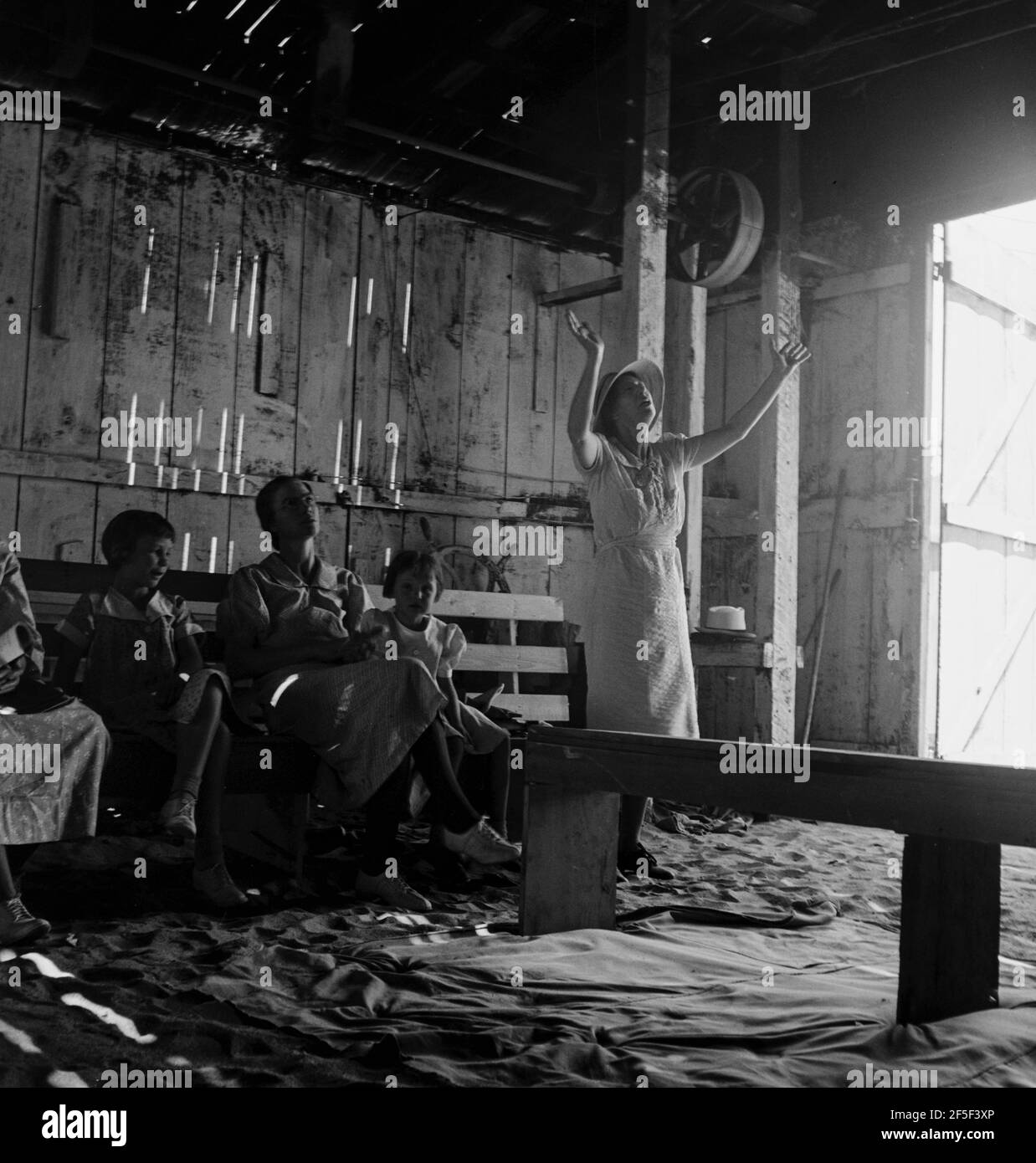 " Vittoria attraverso la Società di Cristo " che tiene la sua Domenica mattina Revival in un garage. DOS Palos, California. Testimonianza: 'E' un meraviglioso salvatore, Gloria a Dio. Sono così felice che sono venuto a casa. Lodate Dio. Il suo amore è così meraviglioso. Sta arrivando presto. Voglio lodare il Signore per ciò che è per me. Mi salvò una volta e mi riempì dello Spirito Santo. Hallalulah! Egli riempirà oggi il vostro cuore di traboccante. Benedite il suo Santo nome . Giugno 1938. Fotografia di Dorothea Lange. Foto Stock