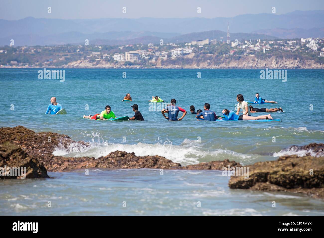 I surfisti messicani insegnano il surf ai turisti alla scuola di surf lungo Playa Zicatela vicino Puerto Escondido, San Pedro Mixtepec, Oaxaca, Messico Foto Stock