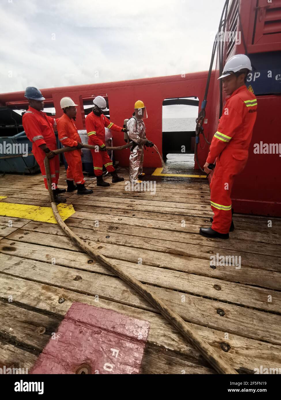 la gente di mare ha effettuato un'esercitazione antincendio mensile sul ponte, per rinfrescare la formazione e testare tutte le pompe antincendio di emergenza e le manichette antincendio Foto Stock