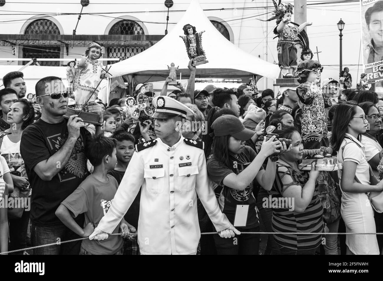 Le persone locali tengono in mano le statue di Santo Nino mentre la Replica Santo Nino De Cebu arriva da Sea, Dinagyang Festival, Iloilo, Filippine. Foto Stock