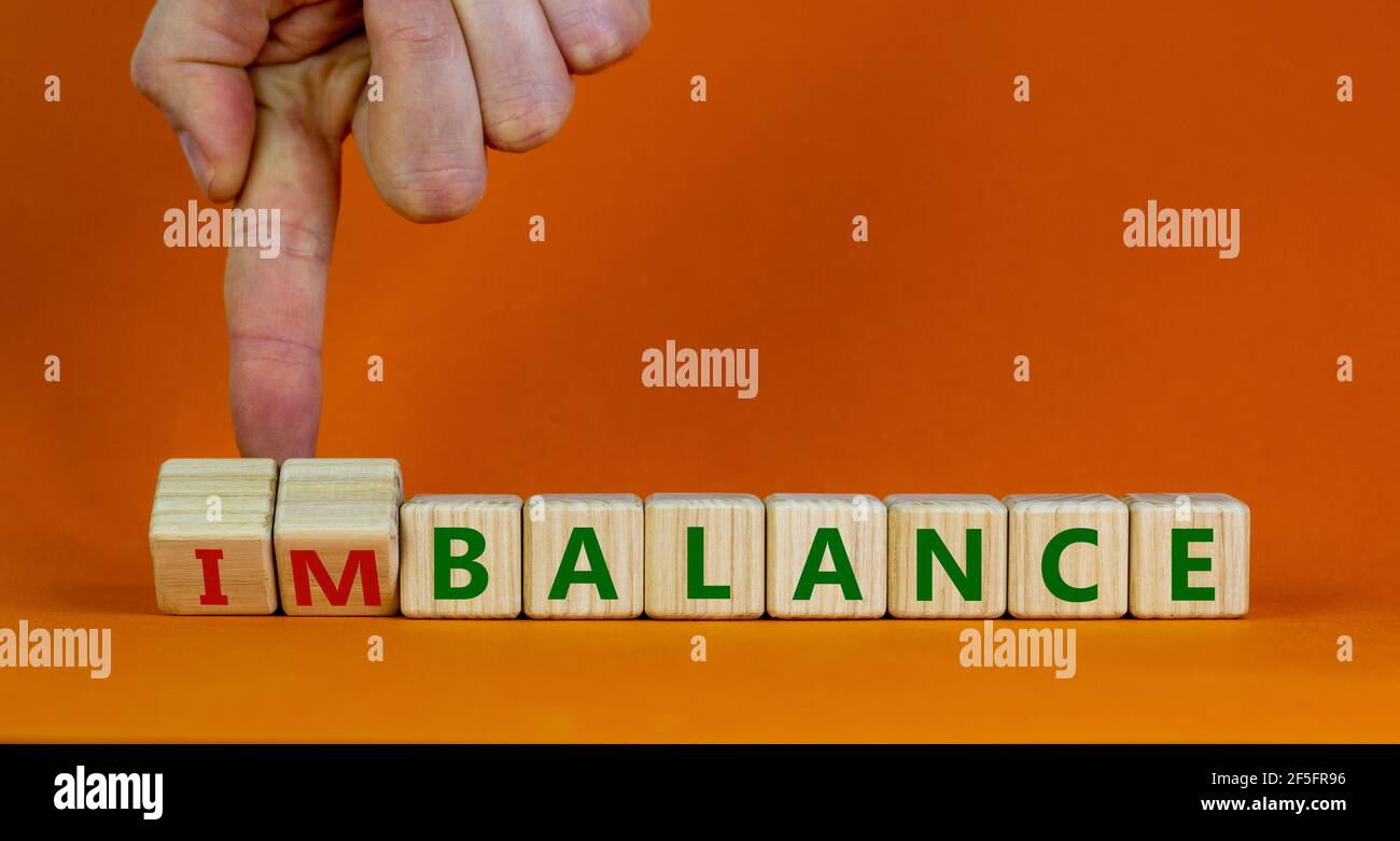 Simbolo di bilanciamento o squilibrio. L'uomo d'affari trasforma i cubi e  cambia la parola disequilibrio in equilibrio. Splendido sfondo arancione,  spazio per la copia. Affari, b Foto stock - Alamy