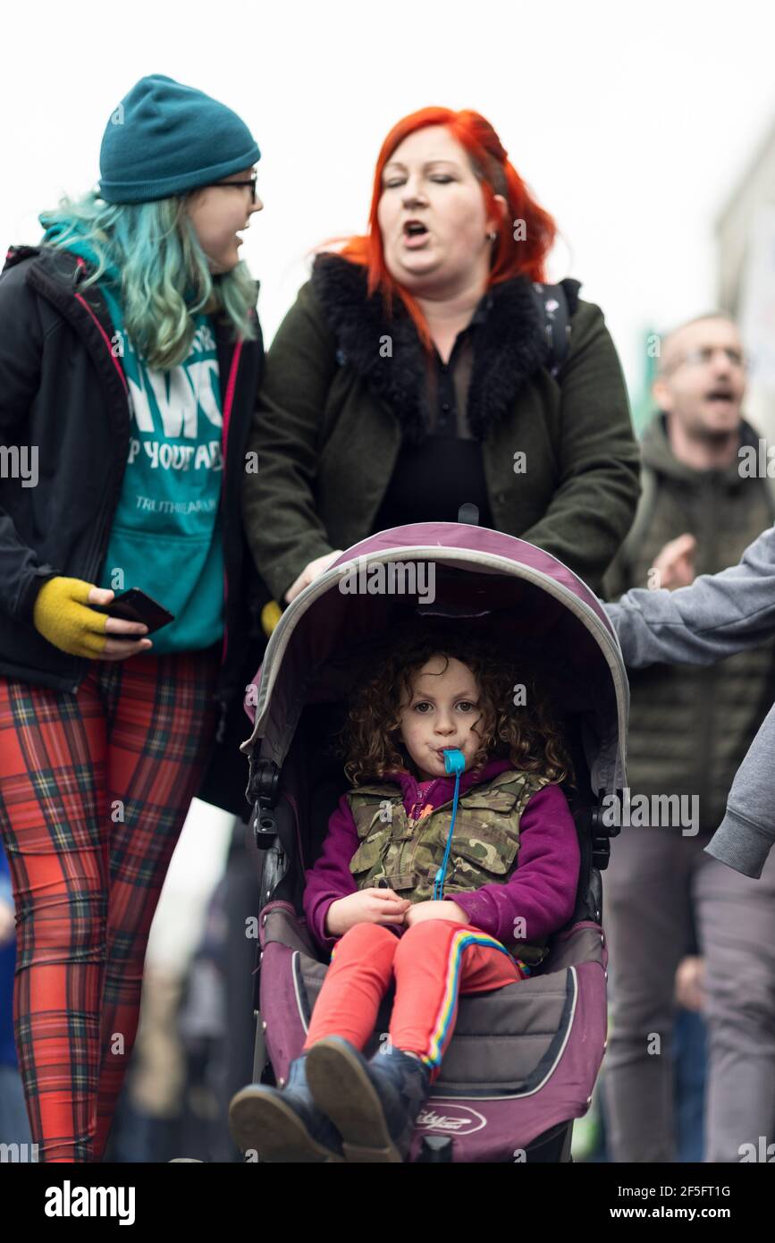 Anti-lockdown e anti Covid-19 vaccinazione protesta, Londra, 20 marzo 2021. Un bambino che soffia un fischio in un gramone. Foto Stock
