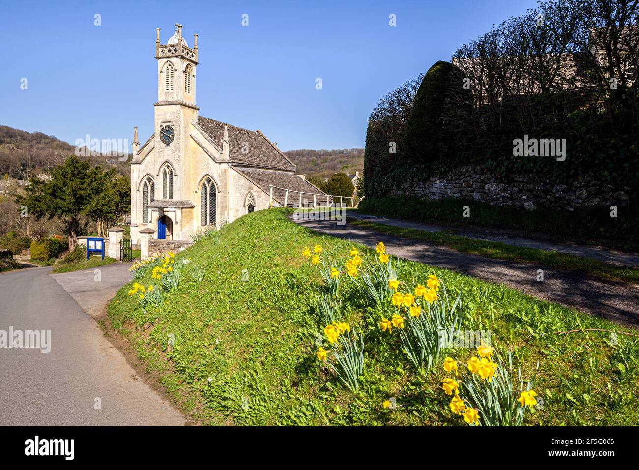 Primavera nel Cotswolds - Daffodils accanto alla chiesa di San Giovanni nel villaggio di Sheepscombe, Gloucestershire UK Foto Stock