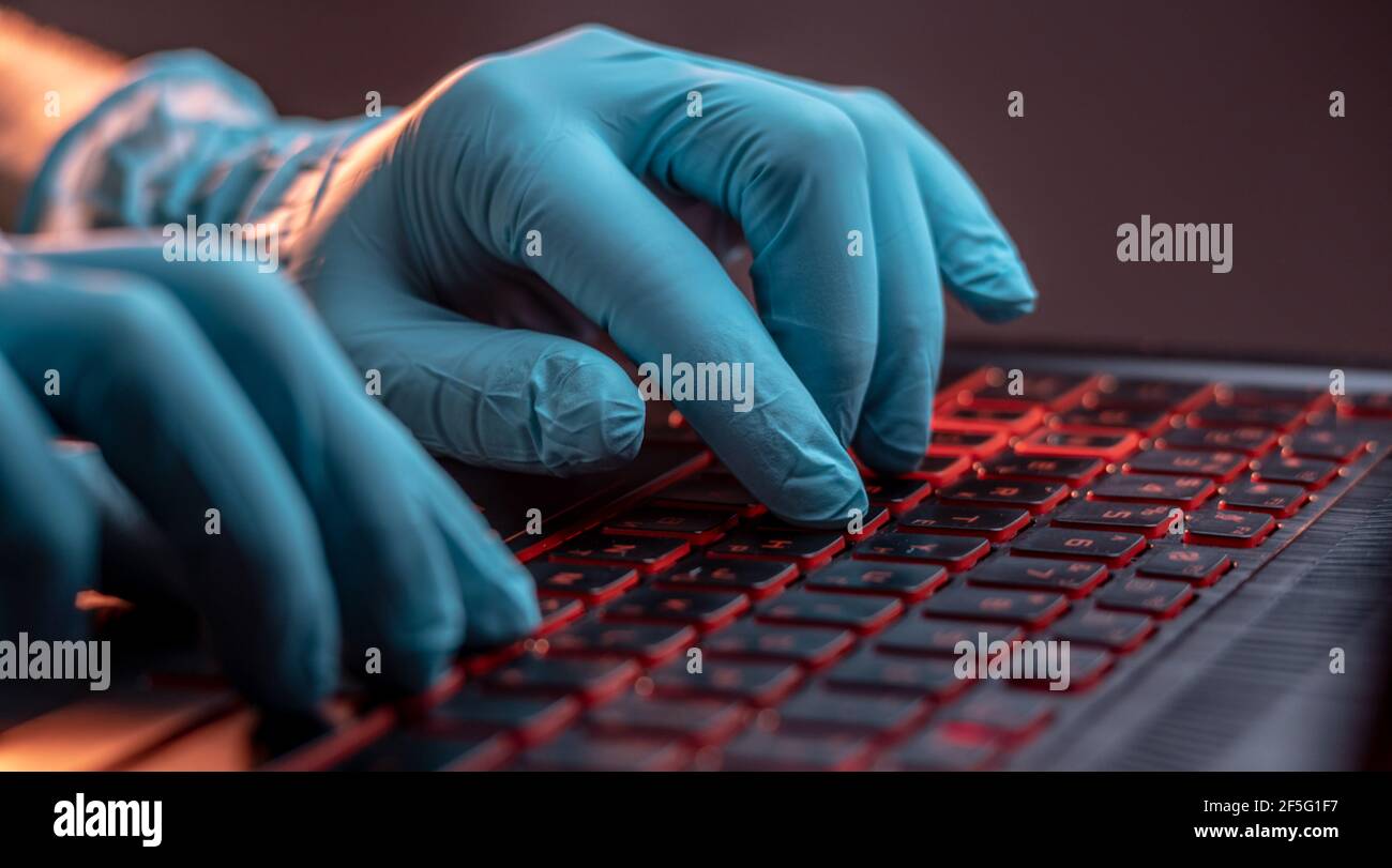 Mani in guanti medici digitare sulla tastiera di un computer portatile in  primo piano. Il concetto di protezione durante il lavoro in quarantena Foto  stock - Alamy