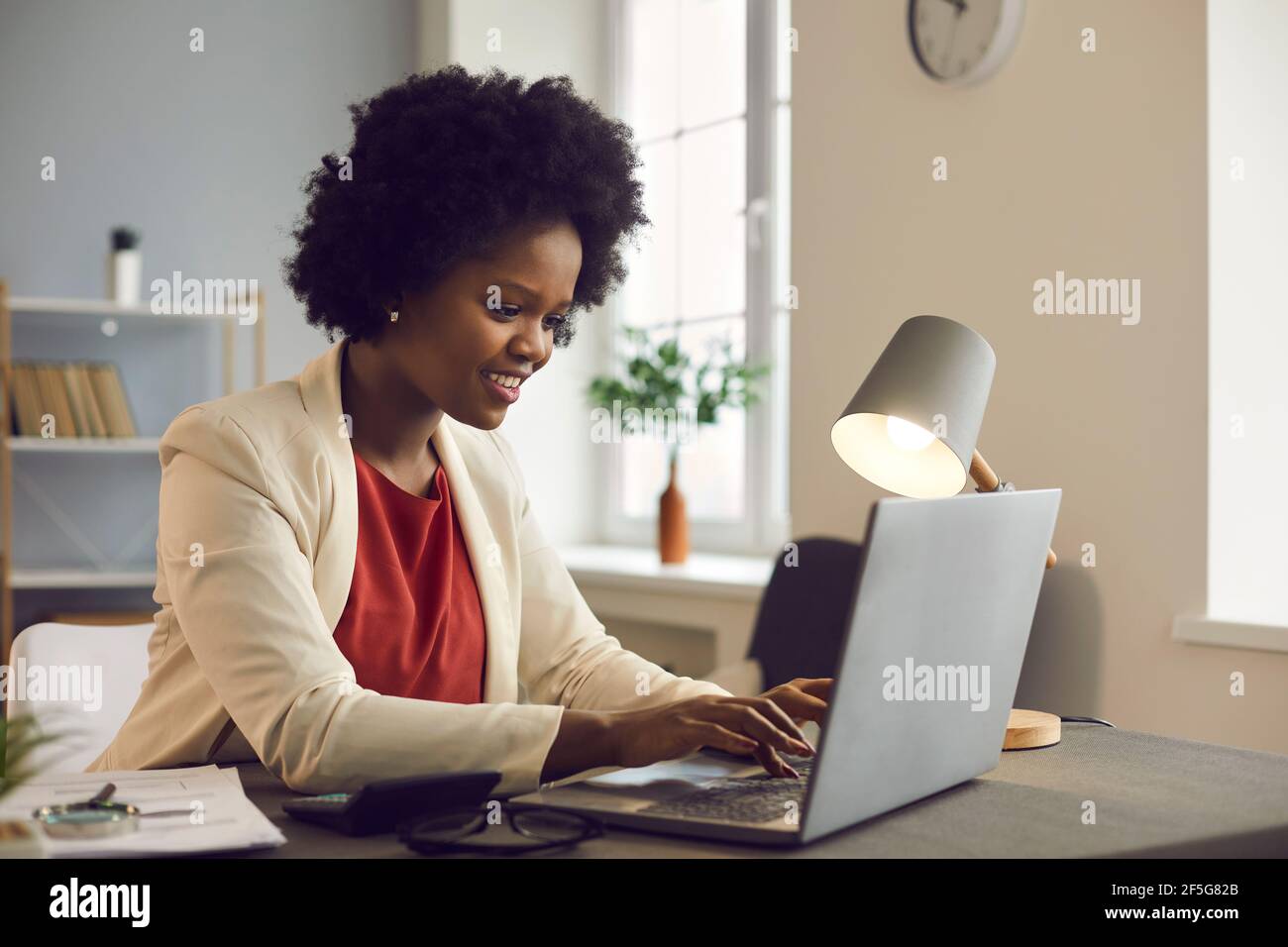 Giovane donna d'affari afro americana che lavora su un computer portatile con documenti elettronici. Foto Stock