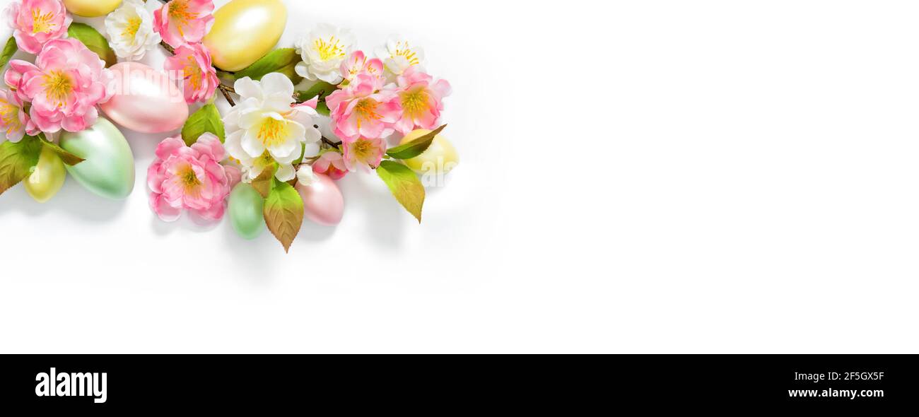 Banner di Pasqua. Uova di Pasqua e fiori decorazione su sfondo bianco Foto Stock