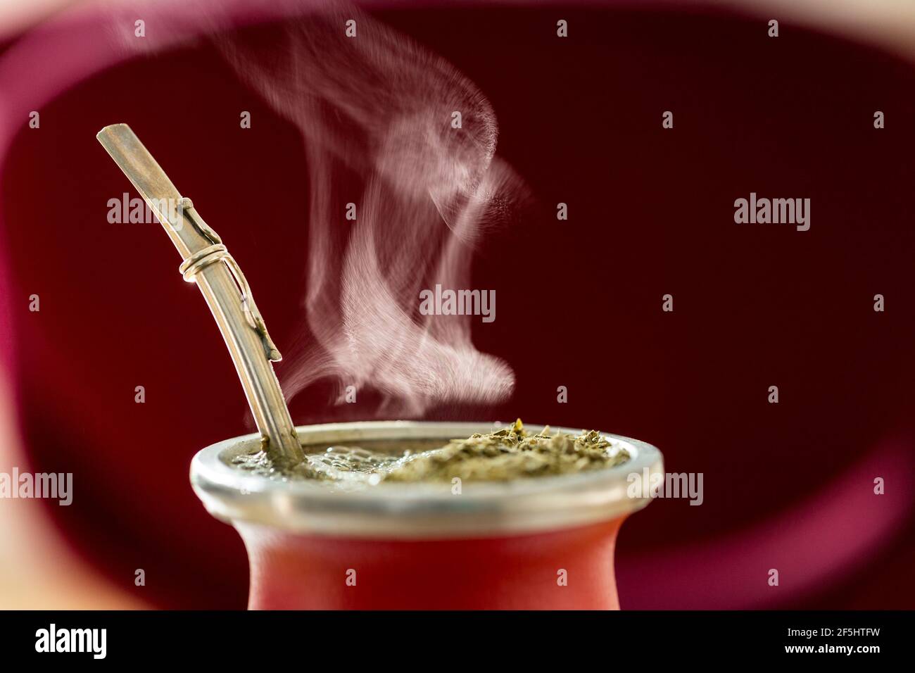 Primo piano orizzontale di Hot Traditional South American, caffeina-ricco infuso bevanda Mate (Yerba Mate) in Red Ceramic Gourd. Infusione di accoppiamento a vapore Foto Stock