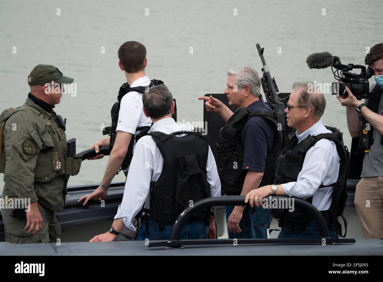 Granejo, USA . 26 Marzo 2021. IL Sen. JOHN HOEVEN, R- North Dakota, punta come una delegazione di diciotto senatori degli Stati Uniti girano il fiume Rio Grande a sud di Mission in quattro Texas Dept. Di pubblica sicurezza gunboats alla fine di un giro whirlwind del Texas del sud. I senatori videro un centro di lavorazione dei migranti sovraffollato a Donna e un cadavere che galleggiava nel fiume a nord del Parco di Anzalduas. Credit: Bob Daemmrich/Alamy Live News Foto Stock