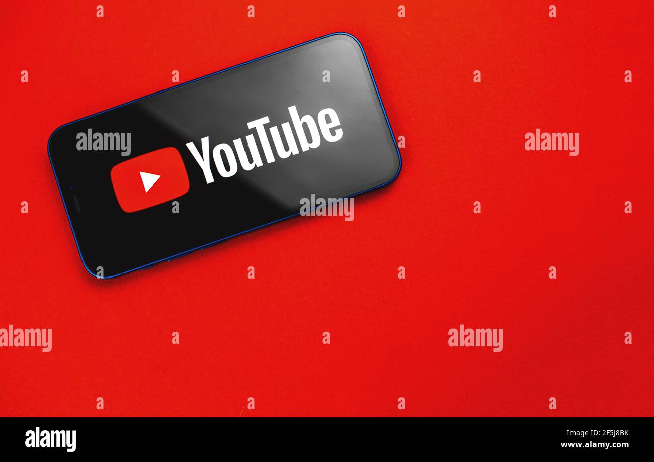 Kharkov, Ucraina - 24 marzo 2021: Spazio di lavoro con applicazione YouTube, sfondo rosso Foto Stock