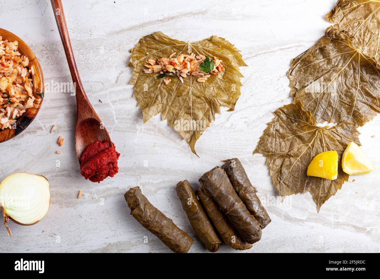 Lo Yaprak sarmasi è un piatto tradizionale turco, fatto da involtini di riso ripieno di foglie d'uva. Immagine piatta che mostra gli ingredienti durante la preparazione Foto Stock