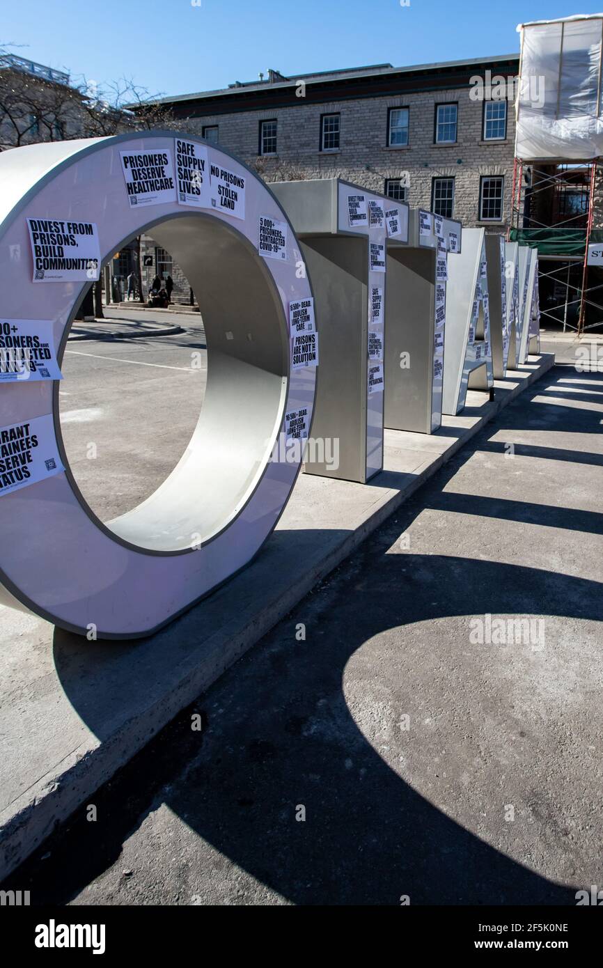 Ottawa, Ontario, Canada - 20 marzo 2021: I segni lasciati dai manifestanti sul segno 'Ottawa' nel mercato di ByWard portano messaggi di condanna del sesto carcerario Foto Stock