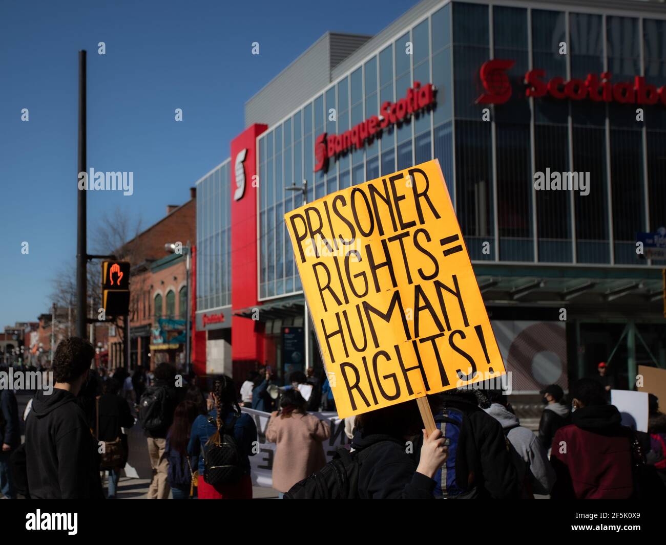 Ottawa, Ontario, Canada - 20 marzo 2021: Un attivista porta un cartello con la scritta "diritti del prigioniero - diritti umani!" mentre marciando in una protesta contro tre Foto Stock
