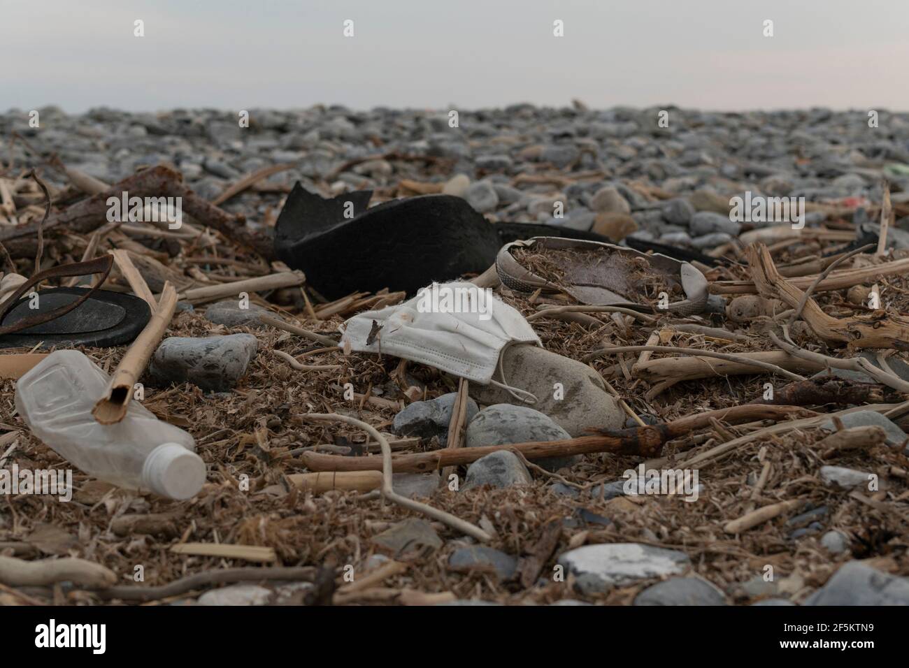 Inquinamento sulla spiaggia, plastica comprese le bottiglie, maschere chirurgiche e altri rifiuti Foto Stock