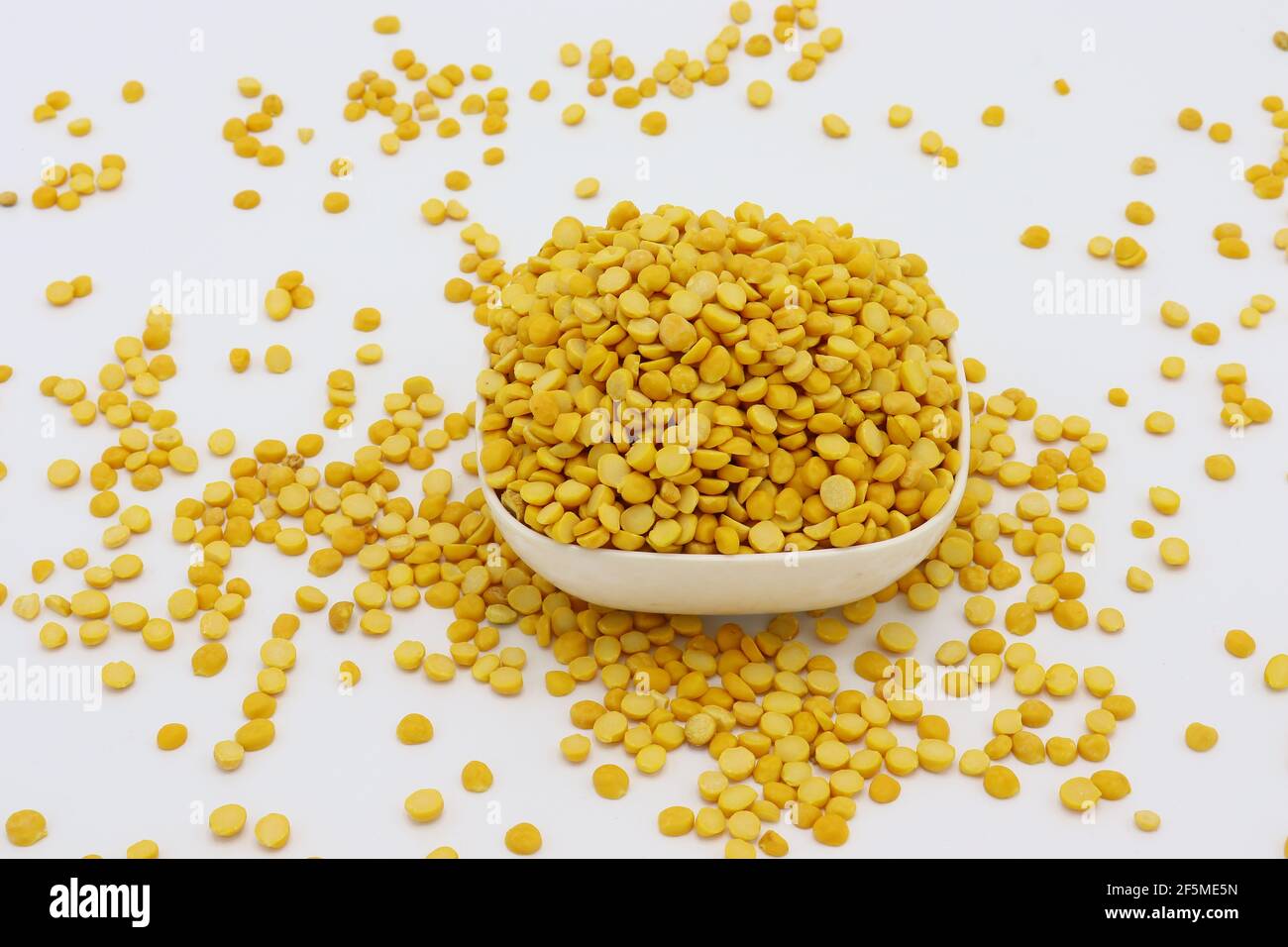 Chickpea anche conosciuto come Chana Daal in un bianco ciotola piccola isolata su sfondo bianco Foto Stock