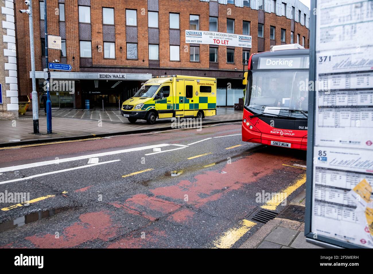 Londra UK, marzo 26 2021, Londra NHS Ambulance e un autobus rosso su una High Street vuota durante il Covid-19 Coronavirus Lockdown Foto Stock