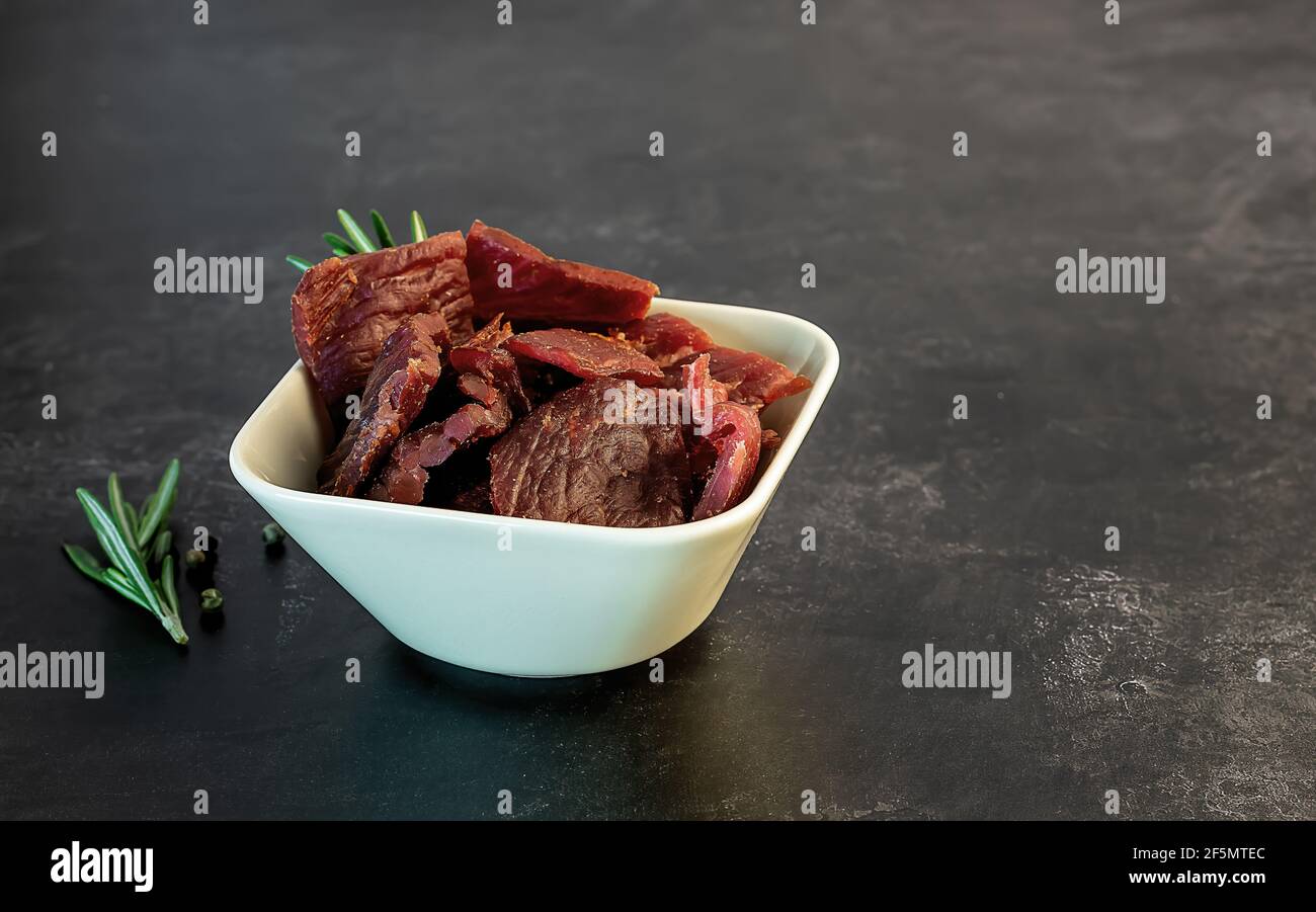 Spuntino a strappo di manzo ad alto contenuto proteico, carne magra. Affumicato, cibo secco. Foto Stock