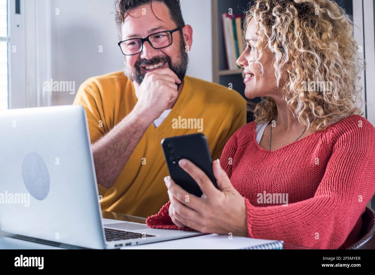 Felice uomo e donna coppia lavoro a casa in intelligente lavoro in ufficio insieme a joy - adulto moderno digitale persone in internet online lavoro activi Foto Stock