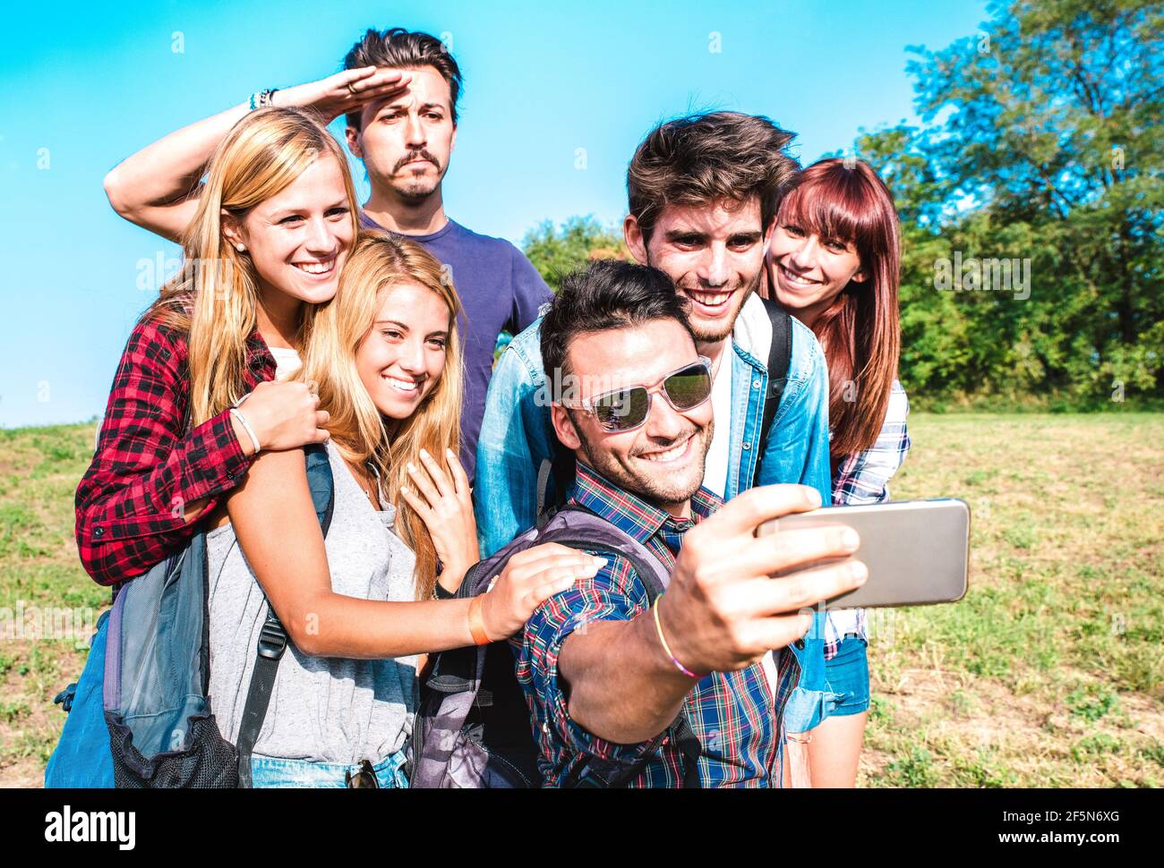 Gruppo di persone che prendono selfie a trekking escursione - felice amicizia e concetto di libertà con i giovani amici milleniali divertirsi insieme in campeggio Foto Stock
