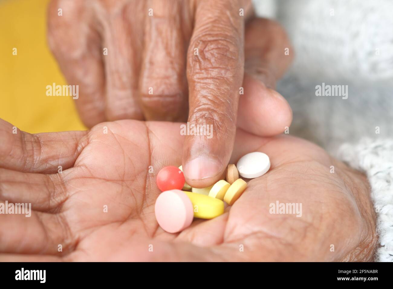 primo piano di pillole mediche e capsule sulle donne anziane mano Foto Stock
