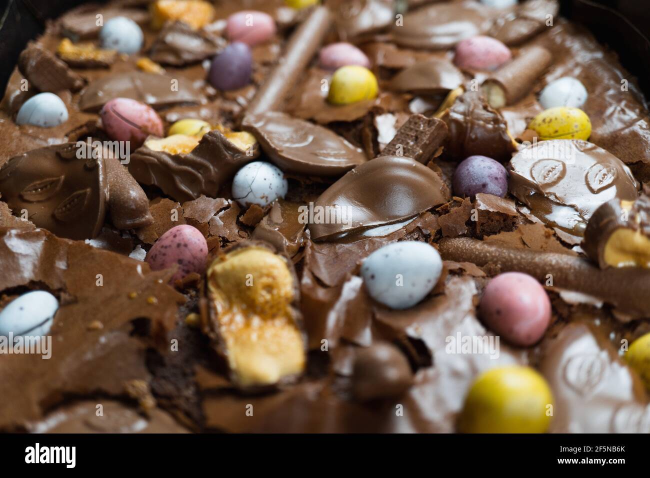 Home cottura concetto di Pasqua. Brownie con barrette di cioccolato, mini uova di pasqua e biscotti cotti al forno. Festa del cioccolato casalinga Foto Stock