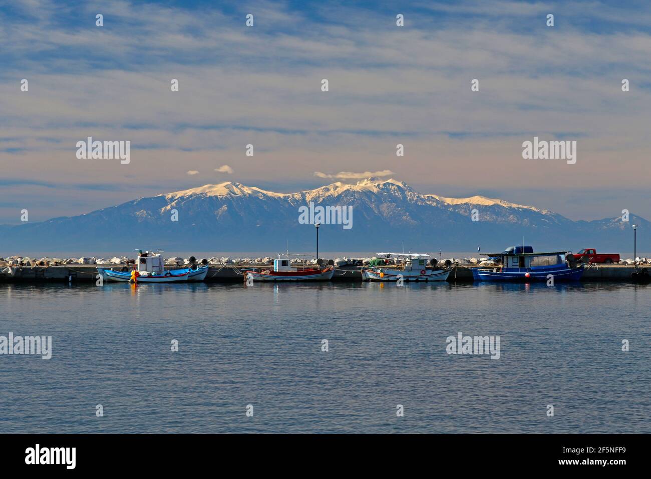Epanomi, Salonicco, Grecia. Ormos Epanomis. Il molo con alcune barche e Olympus montagna sullo sfondo Foto Stock