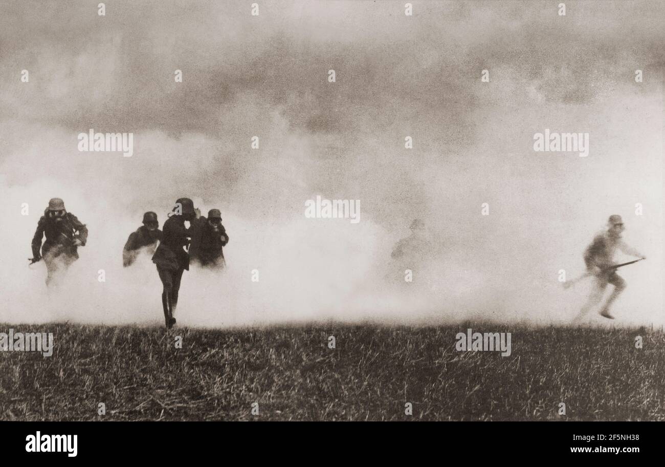 I soldati tedeschi avanzano attraverso il fumo nel campo della battaglia durante la prima guerra mondiale. Foto Stock