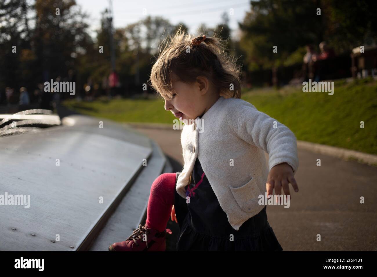 adorabile bimbo sale la fontana nel parco. weekend a piedi con bambini nel parco in buona giornata Foto Stock