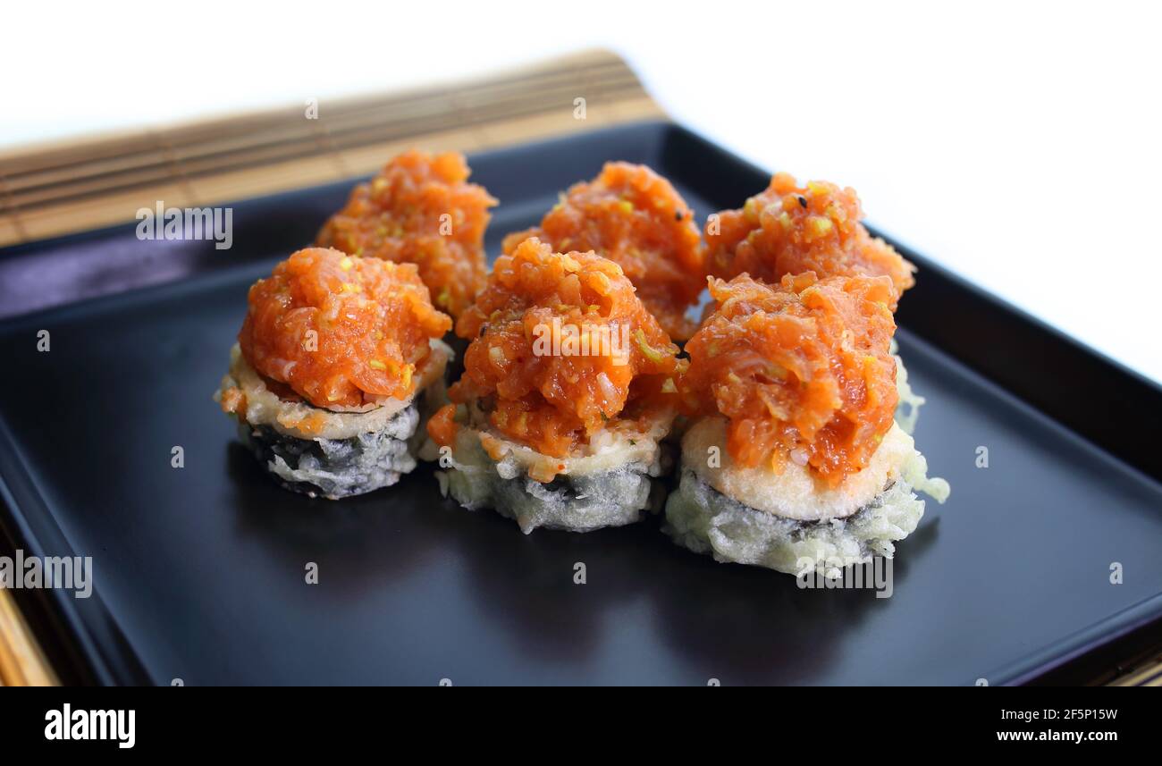 appetitoso sushi tartare di pesce servito piacevolmente su un piatto nero Foto Stock