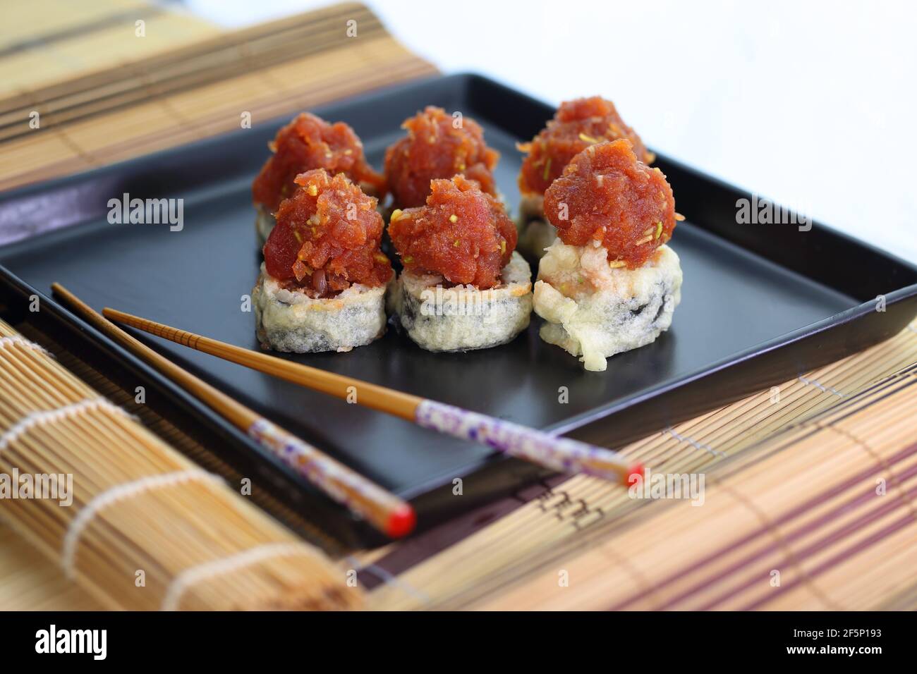 appetitoso sushi tartare di pesce servito piacevolmente su un piatto nero Foto Stock